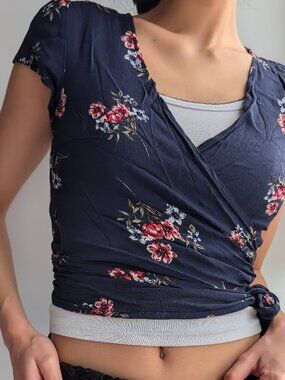 flattering wrap blouse in a deep navy blue with a vibrant red and white rose pri